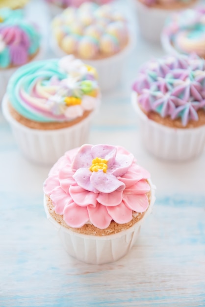 Muchos cupcakes de cumpleaños dulces con flores y crema de mantequilla