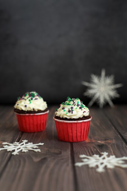 Muchos cupcakes con decoración de año nuevo sobre un fondo oscuro. Concepto de comida, vacaciones, feliz año nuevo.