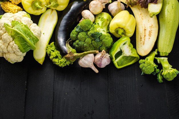 Muchos diferentes de verduras maduras verdes sobre fondo de madera. copia espacio