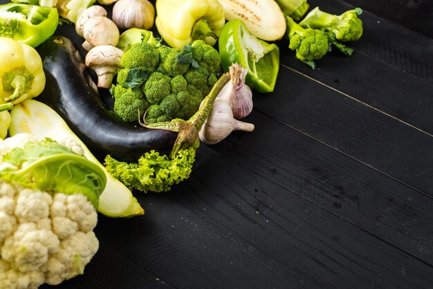 Muchos diferentes de verduras maduras verdes sobre fondo de madera. copia espacio