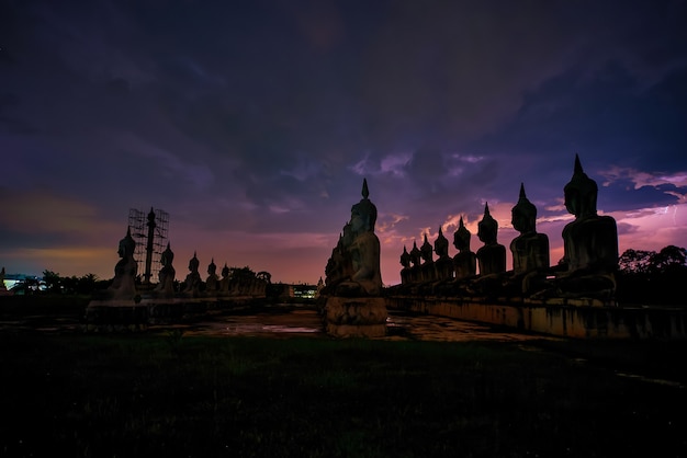 Muchos estatua estatua de Buda con truenos en la noche en el sur de Tailandia