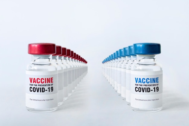 Foto muchos frascos de la vacuna contra el coronavirus covid 19 en la mesa blanca. la concepción médica de la lucha contra la pandemia del covid-19. producción masiva de vacunas.