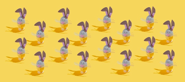 Foto muchos huevos de pascua hechos como conejitos de pascua con diversas emociones sobre un fondo amarillo