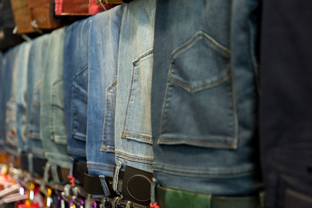 Muchos jeans diferentes en la tienda. Tienda de ropa vaquera