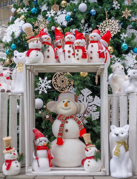 Foto muchos juguetes muñecos de nieve, ciervos, osos y zorros, de pie bajo el árbol, juguetes de navidad,