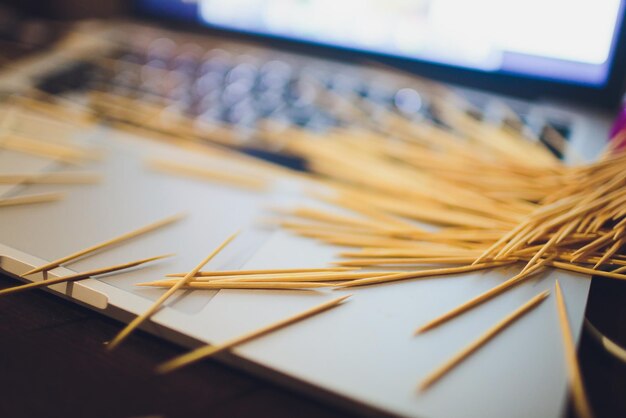 muchos palillos de madera en el fondo de la mesa marrón una computadora portátil