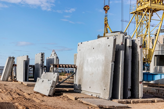 Muchos paneles de pared de hormigón prefabricado se almacenan en el área de almacenamiento esperando su instalación en el sitio de construcción.