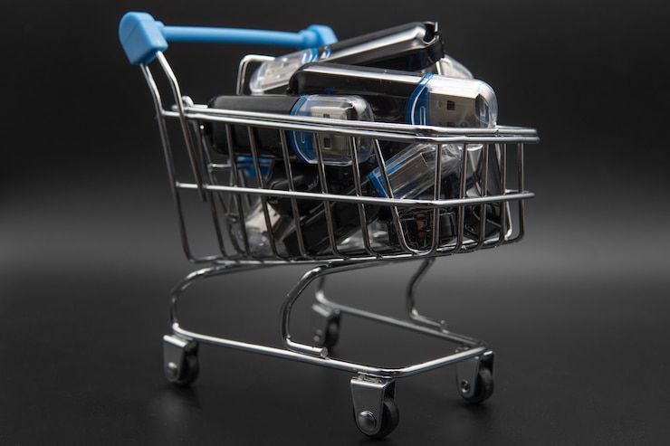 Foto muchos parpadean en un pequeño carrito de compras en un teclado portátil.