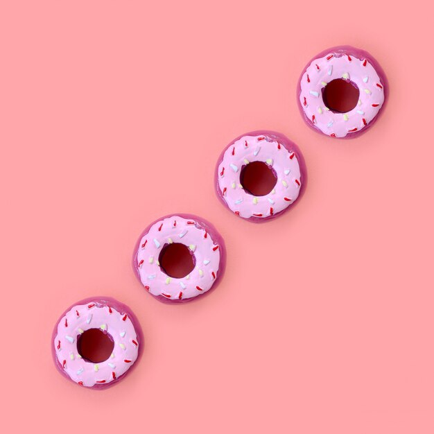 Muchos pequeños donuts de plástico se encuentra en un fondo de colores pastel