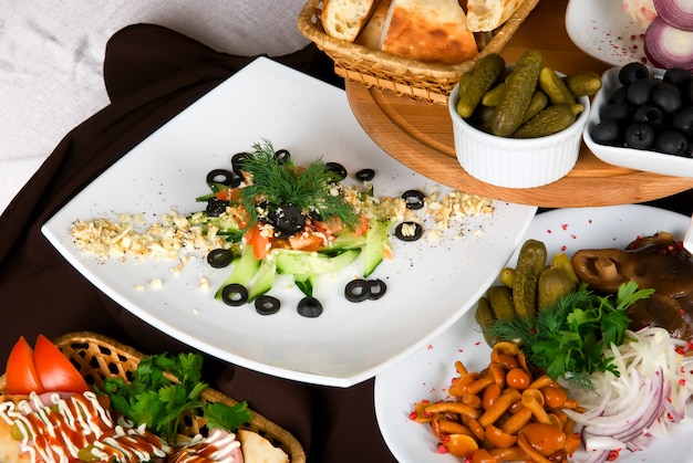 Muchos platos de comida en la mesa del restaurante. Plato de ensalada de cerca