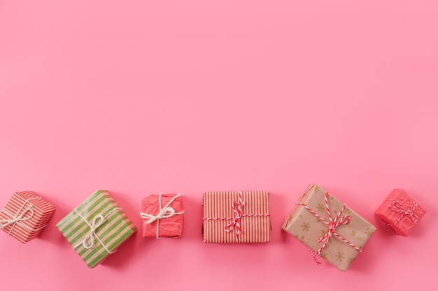 Muchos regalos de Navidad sobre fondo rosa.
