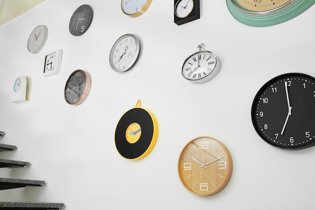 Muchos relojes diferentes colgados en la pared blanca Hora del día