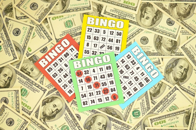 Muchos tableros de bingo o naipes para ganar fichas y una gran cantidad de billetes de dólar Clásico americano o canadiense de cinco a cinco cartones de bingo en dinero