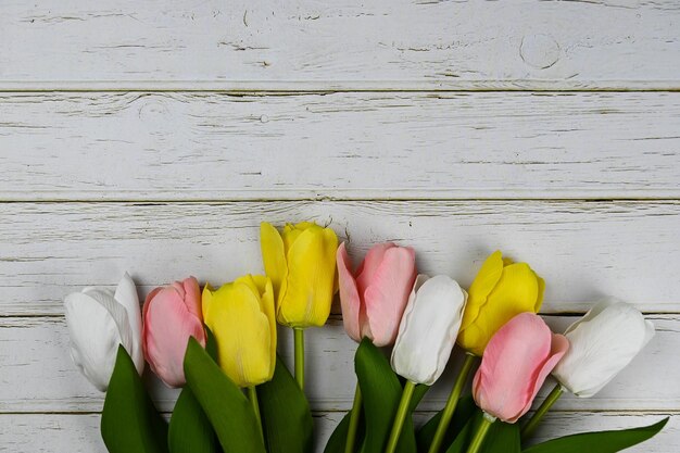 Muchos tulipanes sobre fondo de madera