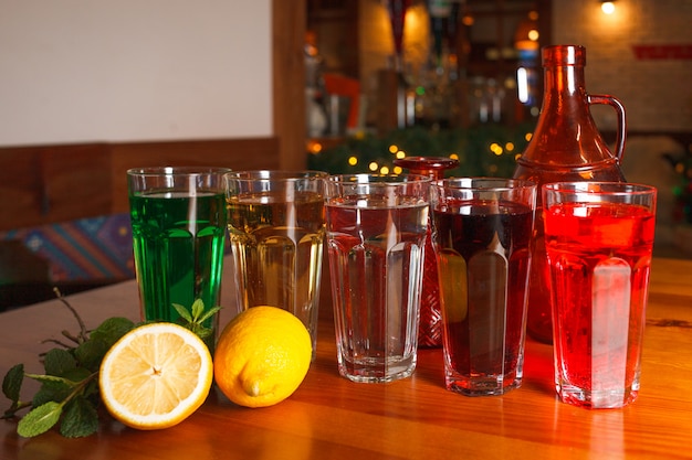 Muchos vasos con varias limonadas naturales en diferentes colores.