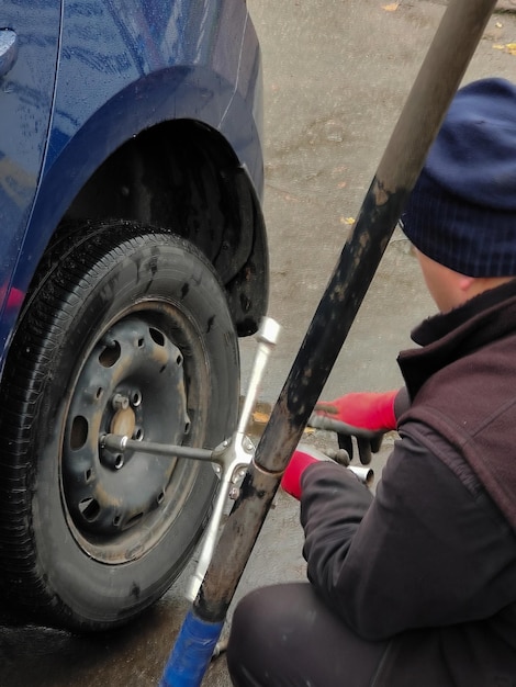 Mudando uma roda em um macaco de carro em uma estação de serviço de carro