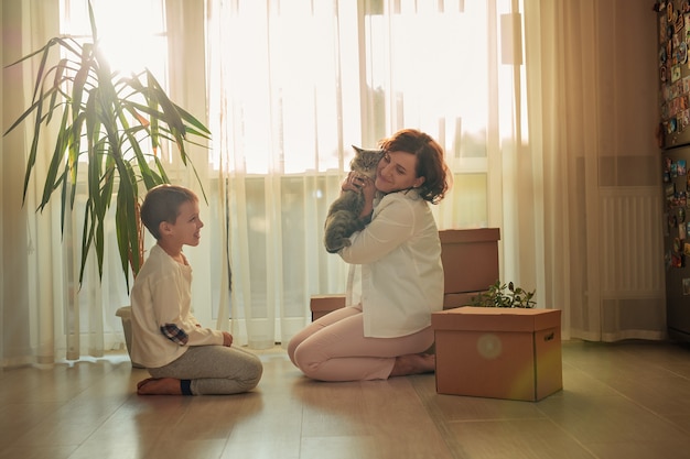 Mudar para uma nova casa. feliz mãe e filho organizando caixas