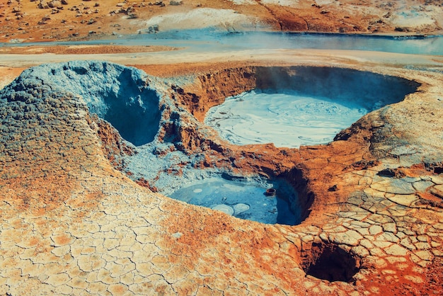 Mudpots en la zona geotérmica de Hverir, Islandia. El área alrededor del lodo hirviendo es multicolor y está agrietada.