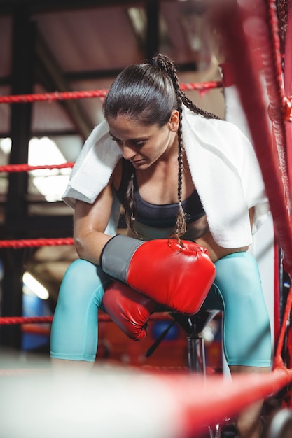 Müde Boxerin, die im Ring sitzt