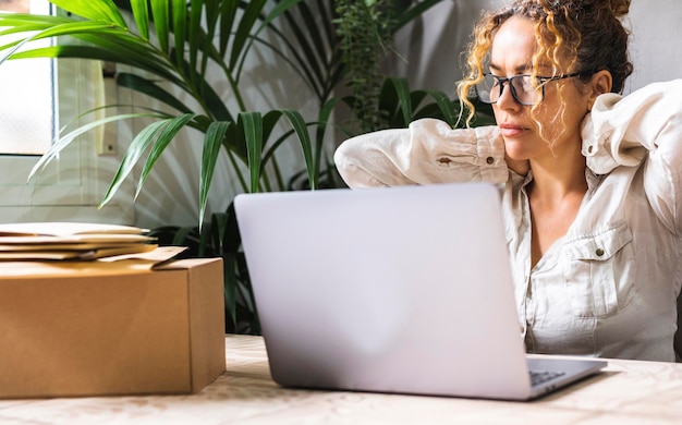 Müde, erschöpfte erwachsene Unternehmerin mit Laptop, Probleme mit dem Projekt, deprimierte Faulheit im Heimbüro im Wohnzimmer, schlechter Tag für Kleinunternehmen, weibliche Arbeit am Computer