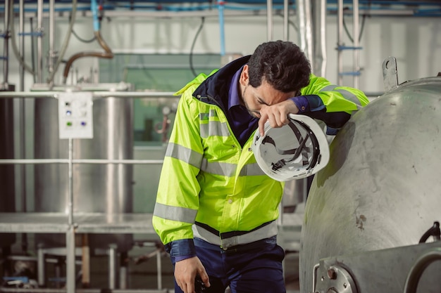 Müde Erschöpfungs-Ingenieur-Arbeiter, die hart in der Fabrik arbeiten. Arbeitnehmer an Corona-Virus-Grippe erkrankt.