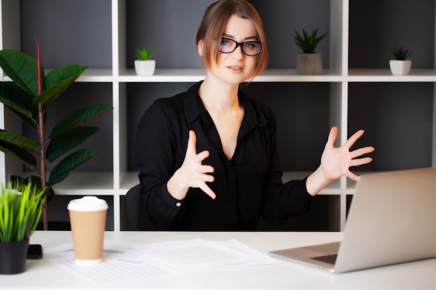 Müde Frau, die am Laptop im Büro arbeitet