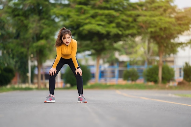 Müde Frau, die sich nach dem Laufen oder Training im Park ausruht