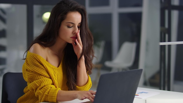 Müde Geschäftsfrau liest Dokumente am Computer Trauriges Mädchen findet Fehler