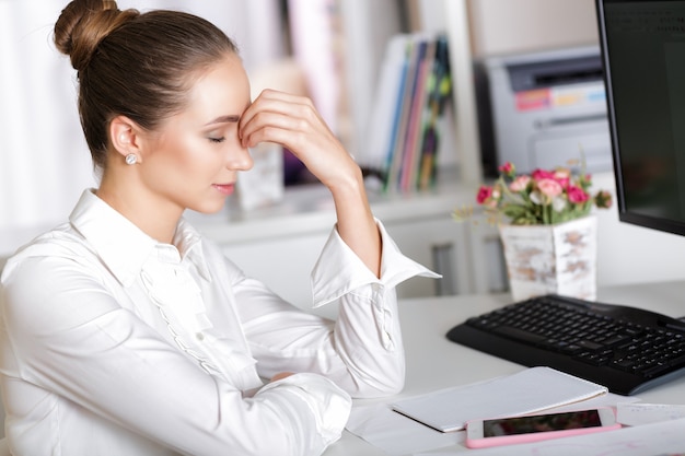 Müde Managerin im Büro nach einem harten Arbeitstag