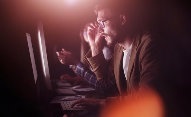 Müde Mitarbeiter, die im Büro bei Nachtfoto mit Kopierraum arbeiten