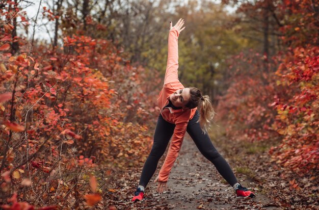 Müde Sportfrau in Sportbekleidung im Herbstwald