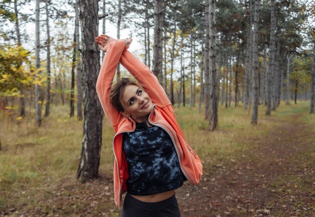 Müde Sportfrau in Sportbekleidung im Herbstwald