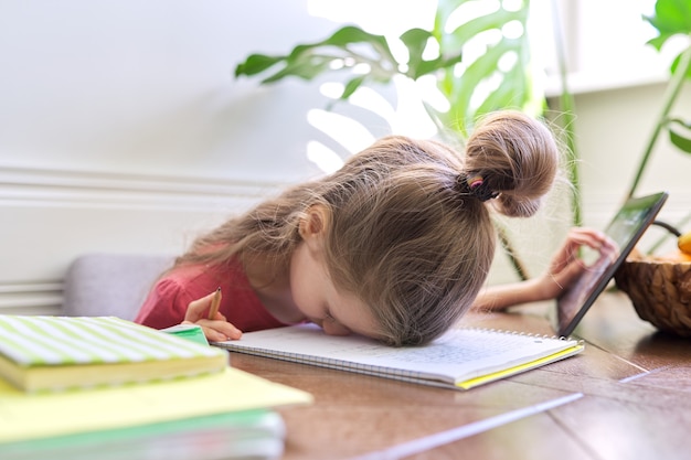 Müde Studentin, die zu Hause studiert, Mädchen in Verzweiflung legte ihren Kopf auf den Tisch.