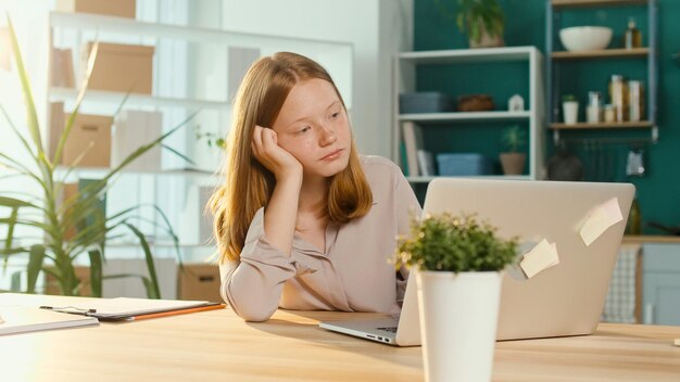 Müde Teenager-Schulmädchen beim Online-Studium an einem Laptop trauriger Student