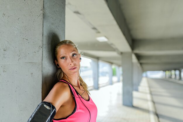 Müde und erschöpfte Frau, die nach intensiver Trainingseinheit stillsteht