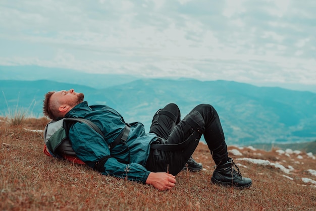 Müde Wanderer ruhen sich während der Wanderung auf dem Berg auf Gras aus Ruhen Sie sich nach sportlicher Aktivität im Freien aus