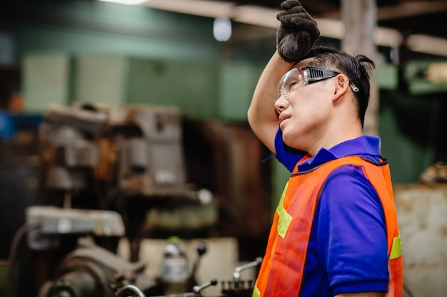 Müder Arbeiter, Kopfschmerzen heißes Wetter über Hitze ungesunder Ingenieur, der in der Schwerindustriefabrik arbeitet.