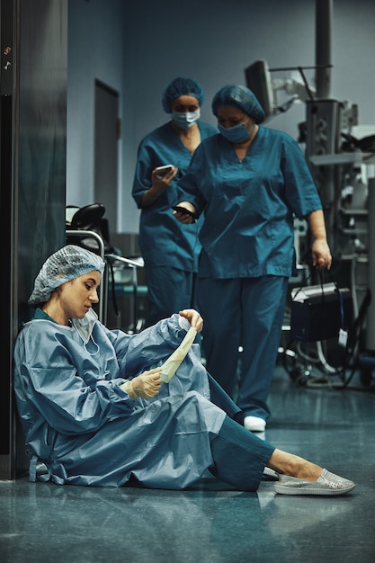 Müder Arzt sitzt nach der Operation im Krankenhausflur