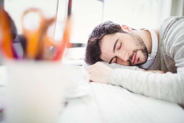 Müder Geschäftsmann, der im Büro ein Schläfchen hält