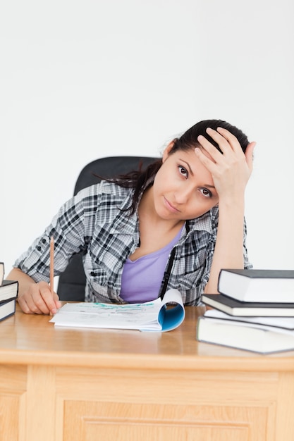 Müder junger Student mit Hausarbeit