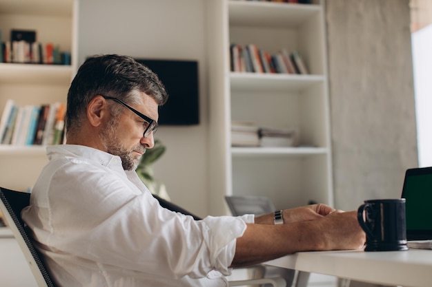 Müder Manager allein im Büro, der Überstunden machtxA