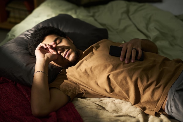 Müder Mann schläft in seinem Schlafzimmer