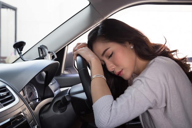 Müder Schlaf der jungen Frau im Auto
