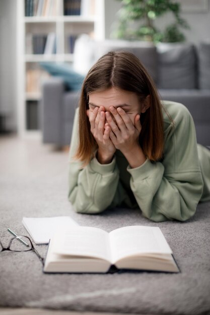 Müder Student mit Büchern zu Hause