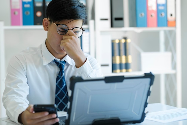 Müder und überarbeiteter Manager, der vor dem Computer sitzt und versucht, seine Augen zu konzentrieren.