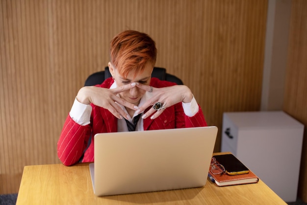 Foto müdige geschäftsfrau in stress arbeitet an einem laptop kopfschmerzen