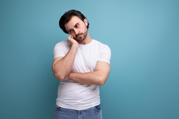 Müdiger brünetter Mann in weißem T-Shirt auf Studio-Hintergrund mit Kopierplatz