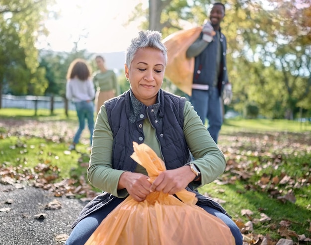 Foto müll-freiwillige und seniorin, die müllverschmutzung oder abfallprodukte zur unterstützung der umwelt reinigt plastiktüte umweltfreundlicher gemeinschaftsdienst und ngo-wohltätigkeitsteam helfen bei der reinigung des naturparks