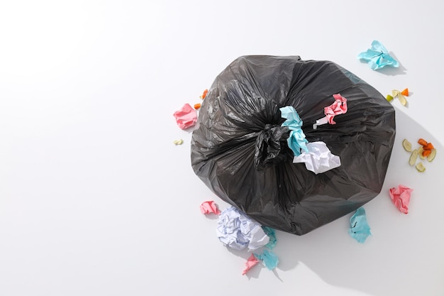 Müllbeutel mit Müll und Papier auf weißem Hintergrund, Platz für Text
