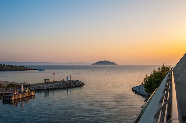 Muelle al atardecer, agua en el mar desde una colina, el barco navega en el mar